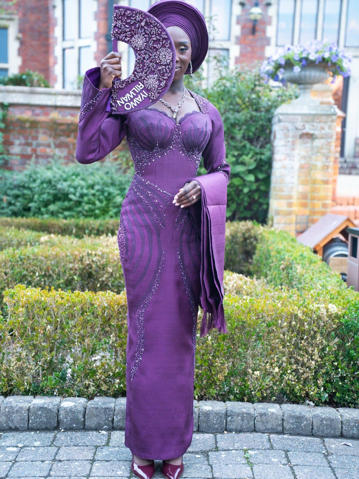 Deep plum beading and a hand-painted fan, the bride's name stitched into the reveal.