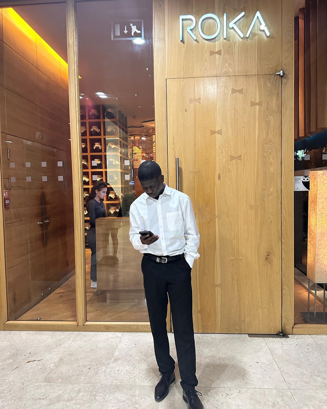 Jaaythecreator outside a restaurant, checking his phone before a shoot